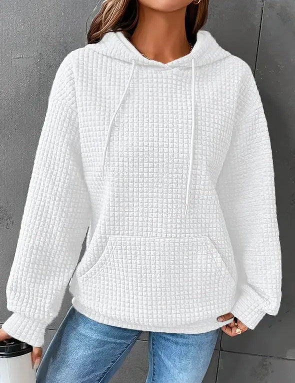 Felpa bianca con cappuccio in tessuto waffle, tasca frontale, indossata da una donna. Stile casual, ideale per l'autunno e l'inverno.