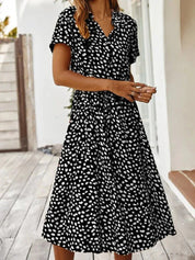 Abito estivo donna nero a pois bianchi, maniche corte, scollo a V, lunghezza media. Moda casual elegante, perfetto per giornate estive.