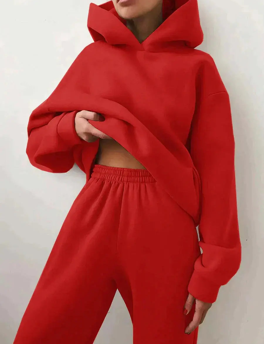 Donna con felpa rossa con cappuccio e pantaloni abbinati, moda casual, abbigliamento sportivo, stile urbano, tendenza autunno inverno.