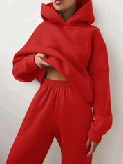 Donna con felpa rossa con cappuccio e pantaloni abbinati, moda casual, abbigliamento sportivo, stile urbano, tendenza autunno inverno.