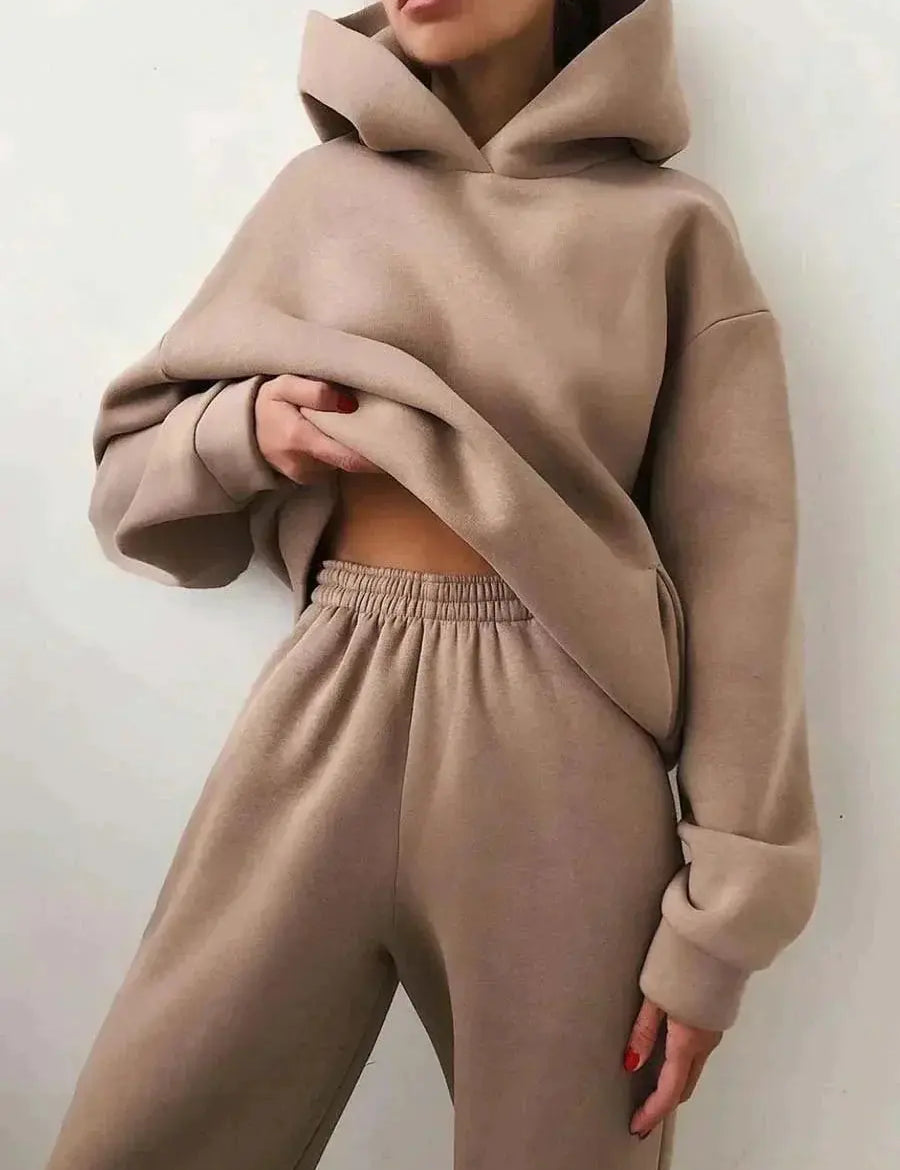 Donna con felpa oversize beige e pantaloni coordinati, moda casual autunno, abbigliamento comodo, stile minimalista, tendenza streetwear.