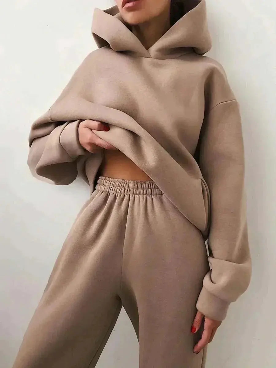 Donna con felpa oversize beige e pantaloni coordinati, moda casual autunno, abbigliamento comodo, stile minimalista, tendenza streetwear.