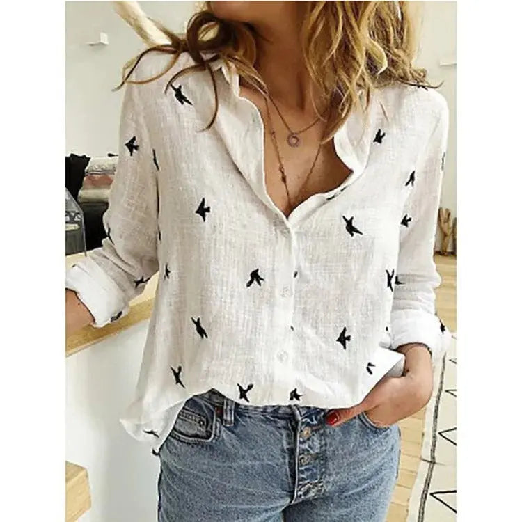 Camicia bianca donna in lino con stampa uccelli neri, abbinata a jeans a vita alta. Look casual chic, moda femminile primavera estate.