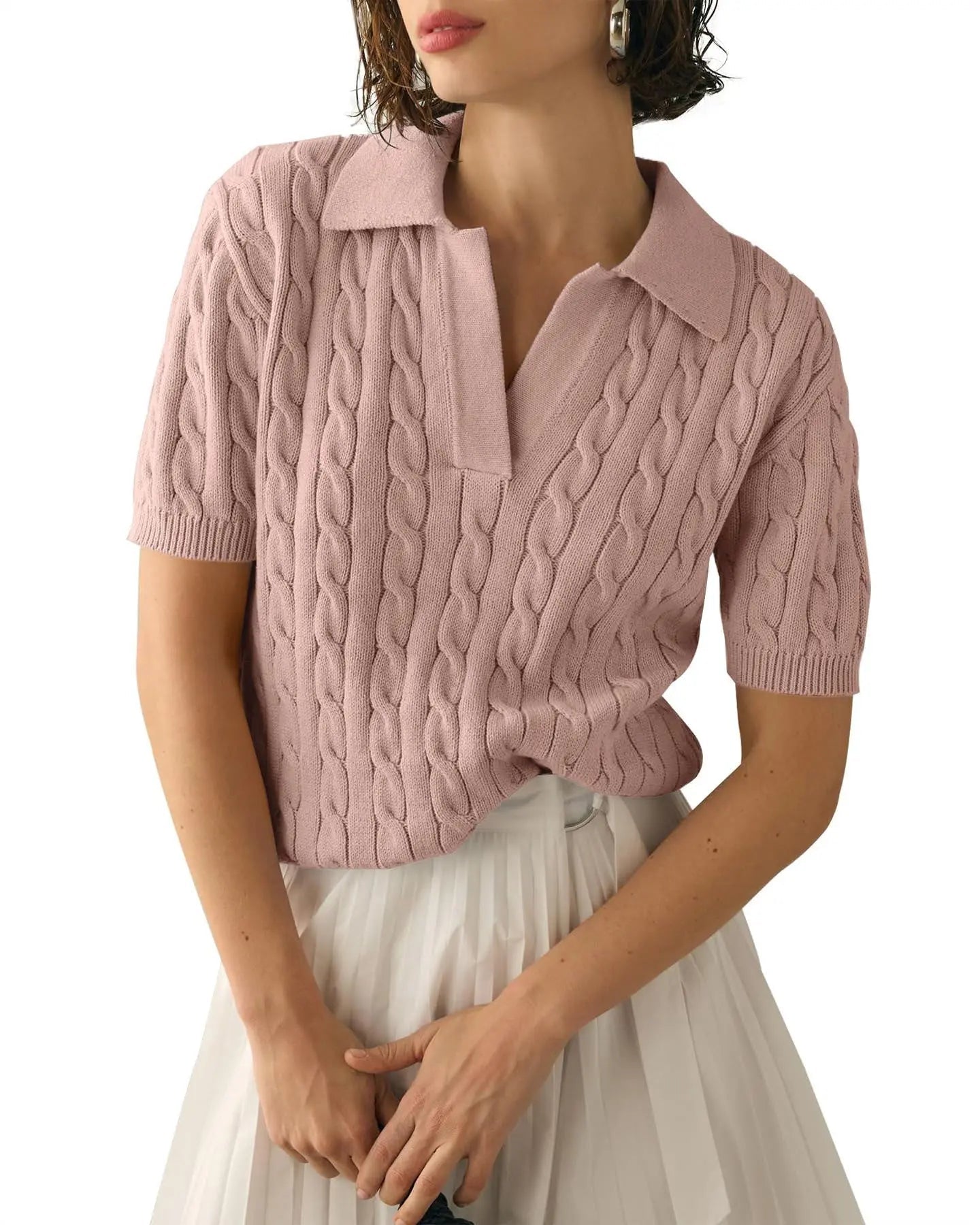 Maglione rosa a trecce da donna con colletto, maniche corte, abbinato a gonna bianca plissettata. Elegante moda femminile casual.