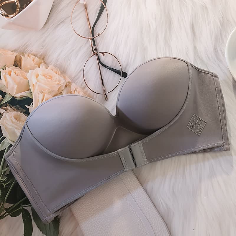 Reggiseno grigio senza spalline su sfondo di fiori e occhiali, ideale per abiti scollati. Design elegante e confortevole, perfetto per ogni occasione.