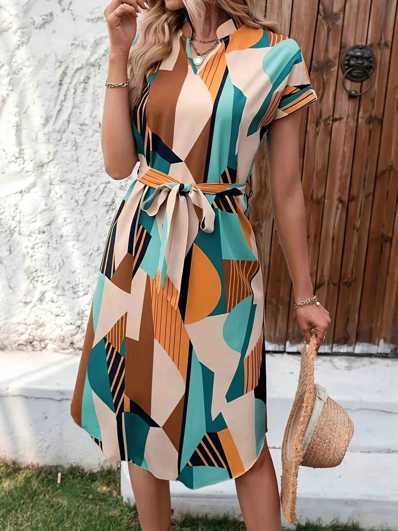 Abito estivo geometrico multicolore, donna, con cintura in vita, maniche corte, sfondo legno, moda casual, perfetto per giornate calde.