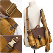 Borsa a tracolla in tela marrone con dettagli in pelle, fibbie in metallo, chiusura a scatto, mostrata su manichino. Ideale per lavoro e viaggio.