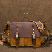 Borsa a tracolla in pelle marrone e tela, stile vintage, con fibbie in metallo. Ideale per lavoro o viaggio. Design robusto e spazioso.