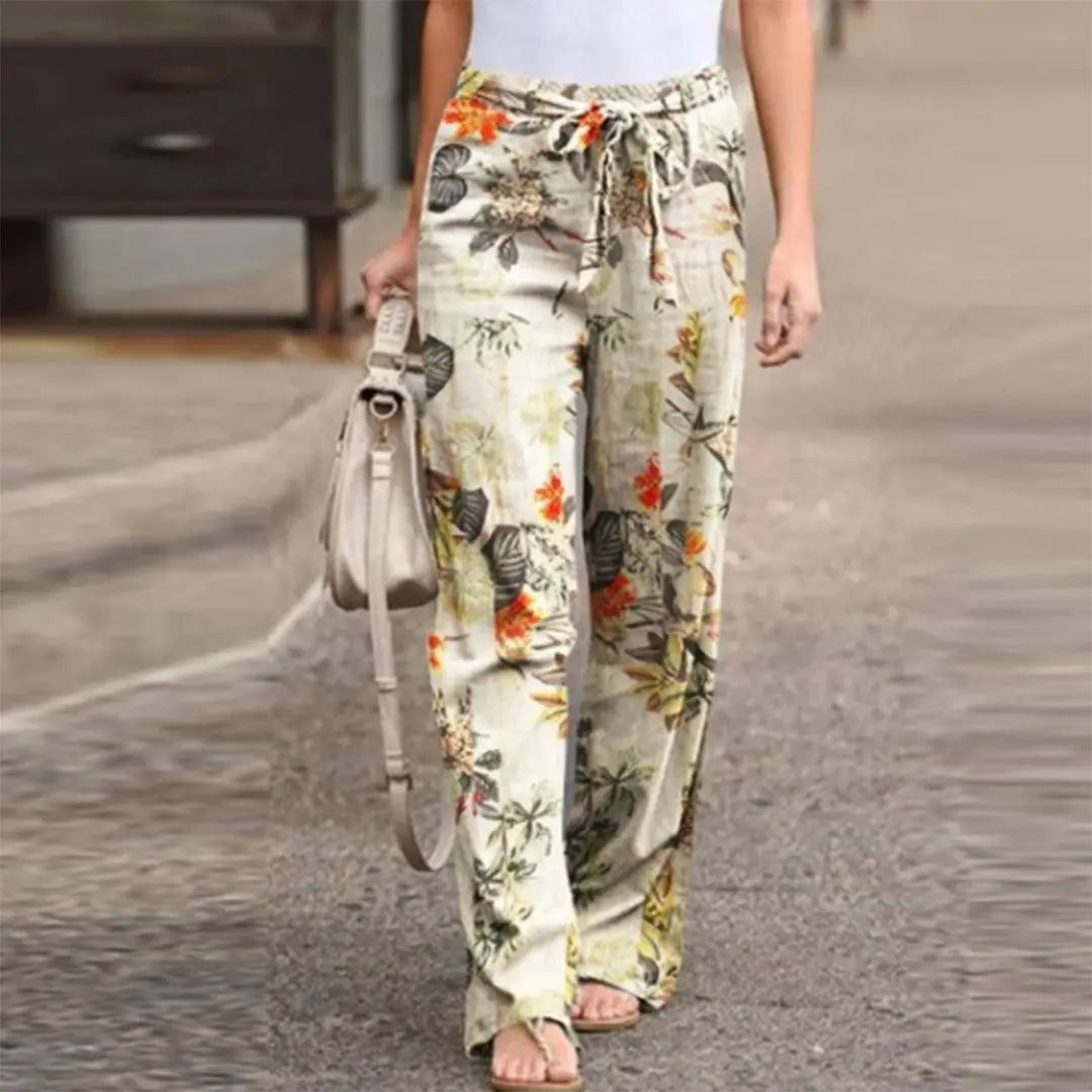 Pantaloni donna a vita alta con stampa floreale, colori vivaci, tessuto leggero, perfetti per l'estate. Stile casual, moda femminile.