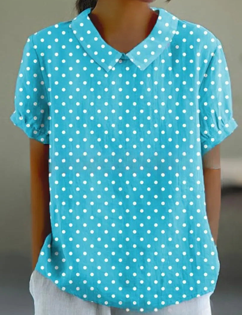 Camicia donna azzurra a pois bianchi, maniche corte, colletto classico. Moda estiva casual, tessuto leggero, stile elegante e fresco.