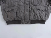Giacca trapuntata grigia invernale, design moderno, chiusura a bottoni, tasche frontali, ideale per moda uomo, abbigliamento caldo e casual.