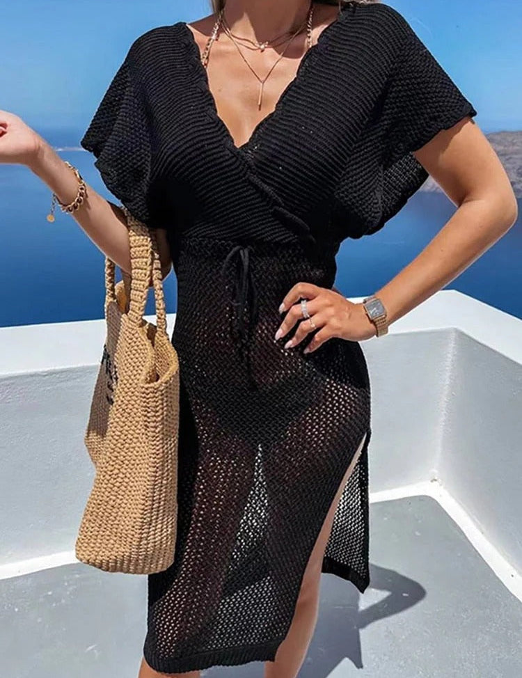 Donna con abito nero trasparente estivo, borsa di paglia, sfondo marino. Moda estiva, abbigliamento da spiaggia, stile elegante.