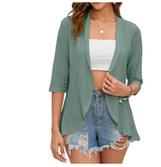 Donna con cardigan verde traforato, top bianco e shorts di jeans strappati. Moda casual estiva, abbigliamento femminile trendy.
