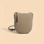 Borsa a tracolla beige in pelle, design minimalista, chiusura con zip, ideale per moda donna, accessorio elegante e versatile.