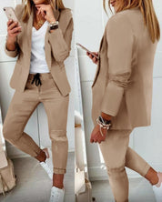 Completo donna beige elegante, giacca e pantaloni, abbinato a t-shirt bianca e sneakers. Moda casual chic, outfit primaverile.
