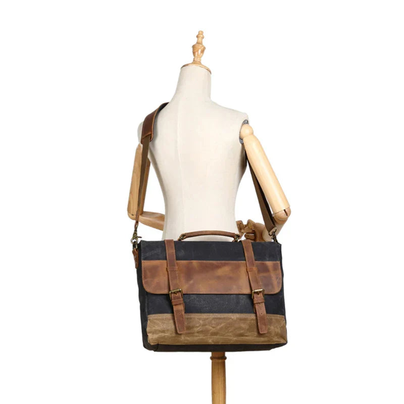 Borsa messenger in tela cerata e pelle marrone su manichino, stile vintage, tracolla regolabile, ideale per lavoro e viaggio.