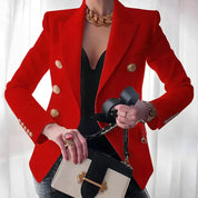 Giacca rossa elegante con bottoni dorati, indossata su top nero. Accessori: collana dorata, borsa a mano bicolore, anello rosso. Moda donna chic.