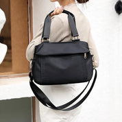 Borsa a tracolla nera da donna, design elegante e moderno, con manici e cerniera dorata, ideale per moda casual e uso quotidiano.