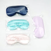 Quattro maschere per dormire in raso, colori blu, turchese, rosa e lilla, confezionate singolarmente. Accessori per il sonno, comfort e relax.