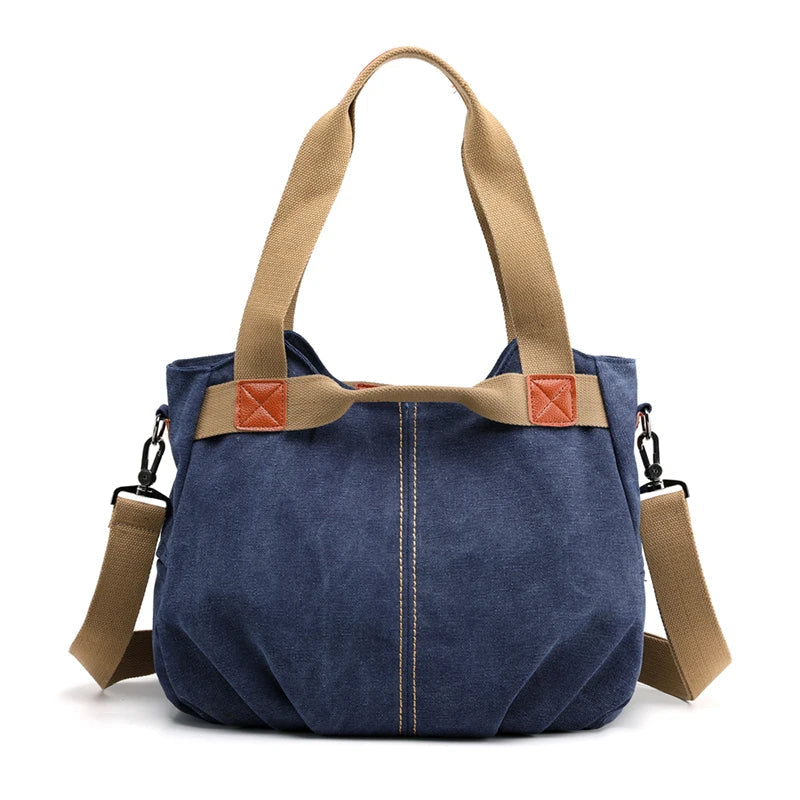 Borsa a tracolla in tela blu con manici beige, dettagli in pelle marrone, design casual e spazioso. Perfetta per uso quotidiano e shopping.
