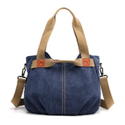 Borsa a tracolla in tela blu con manici beige, dettagli in pelle marrone, design casual e spazioso. Perfetta per uso quotidiano e shopping.
