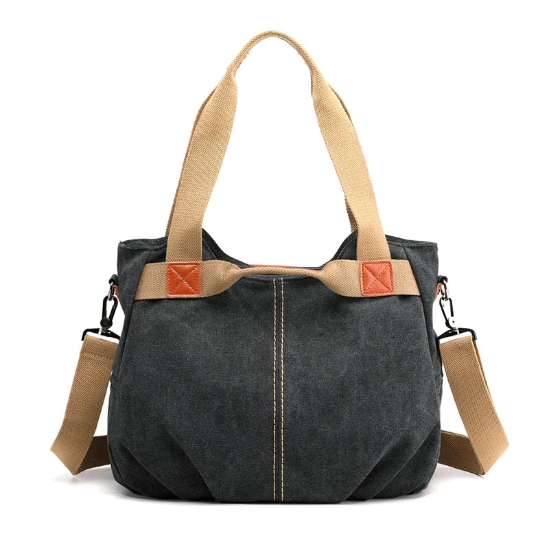 Borsa a tracolla in tela nera con manici beige e dettagli in pelle marrone. Design casual, ideale per uso quotidiano e shopping.