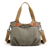 Borsa a tracolla in tela verde oliva con manici marroni, dettagli in pelle, e tracolla regolabile. Design casual e spazioso per uso quotidiano.