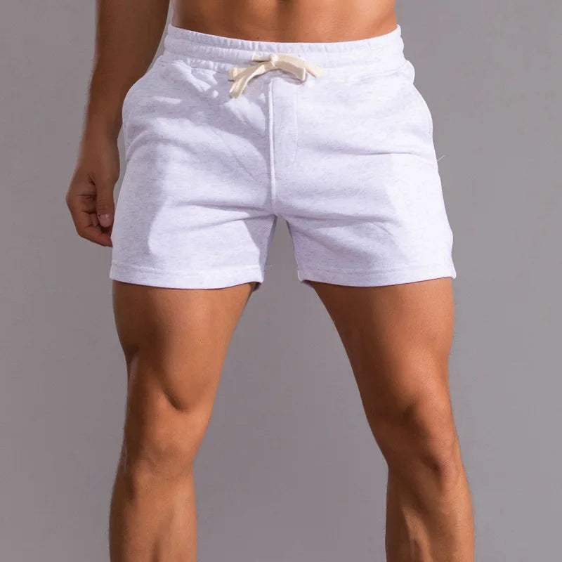 Shorts sportivi da uomo bianchi, tessuto leggero, elastico in vita con laccio, ideali per palestra, fitness e attività all'aperto.