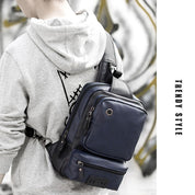 Zaino a tracolla in pelle blu scuro, indossato da una persona con felpa grigia. Design moderno, ideale per moda urbana e viaggi.