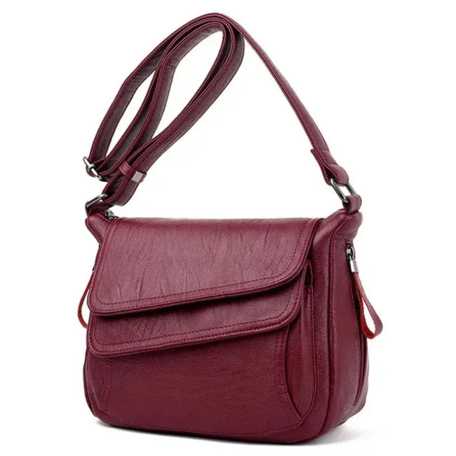 Borsa a tracolla in pelle rossa, design elegante, chiusura a patta, tasche multiple, ideale per donna, moda autunno inverno, accessorio versatile.