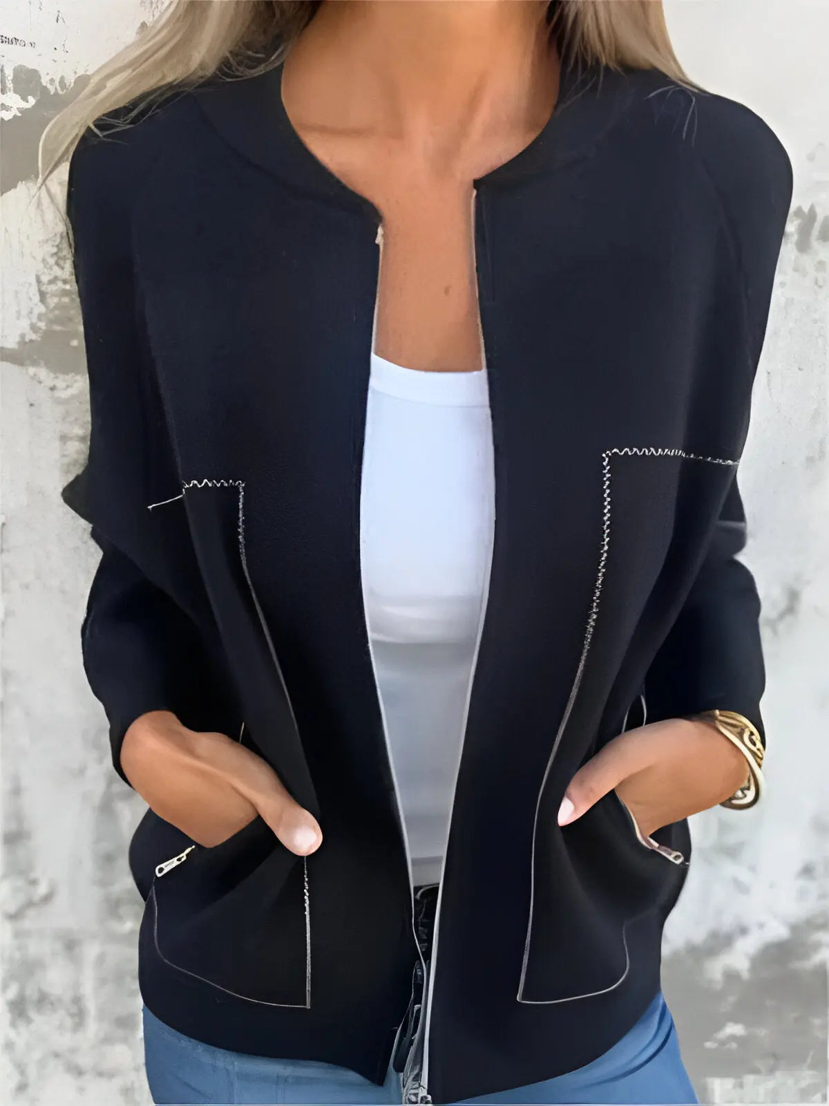 Giacca nera da donna con cuciture bianche, indossata sopra una maglietta bianca. Moda casual elegante, perfetta per l'autunno.