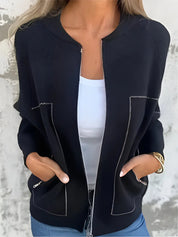 Giacca nera da donna con cuciture bianche, indossata sopra una maglietta bianca. Moda casual elegante, perfetta per l'autunno.