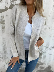 Giacca donna beige in tessuto morbido, con zip frontale, indossata su maglietta bianca e jeans. Look casual chic, moda autunnale.
