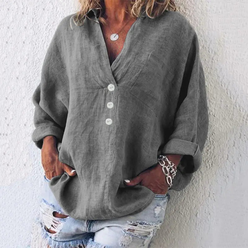 Camicia donna in lino grigio con bottoni bianchi, maniche lunghe arrotolate, abbinata a jeans strappati. Stile casual elegante.