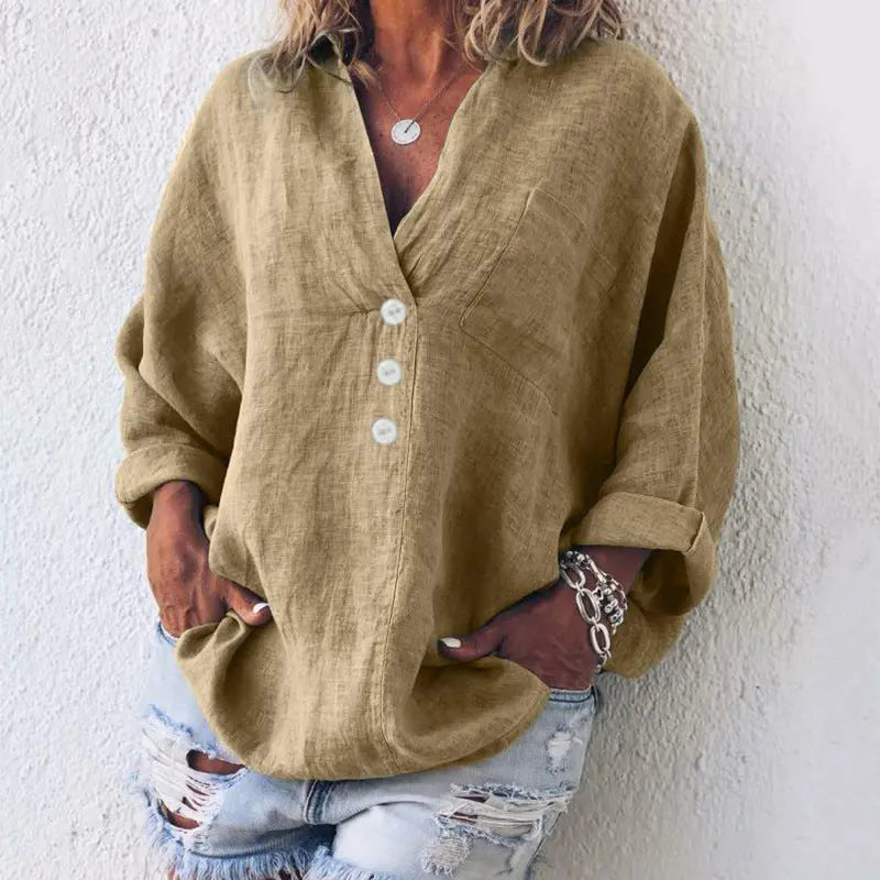 Camicia donna in lino beige con bottoni bianchi, maniche lunghe arrotolate, abbinata a jeans strappati. Stile casual, moda estiva.