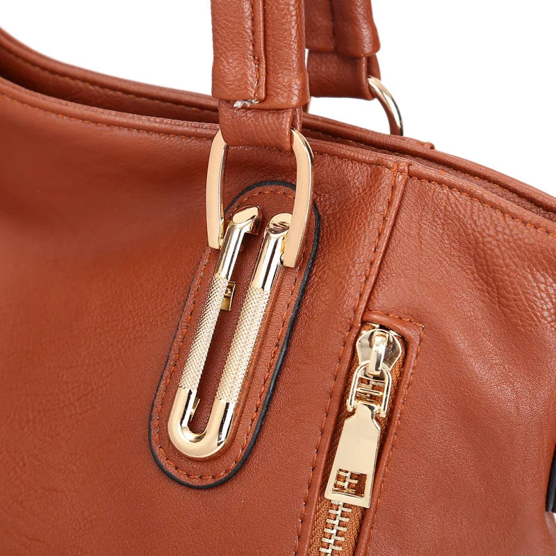 Borsa in pelle marrone con dettagli in metallo dorato, chiusura a zip, manici robusti. Accessorio moda elegante e versatile per donna.