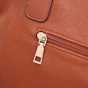 Borsa in pelle marrone con cerniera dorata, dettaglio elegante e moderno. Accessorio moda donna, alta qualità, stile casual chic.