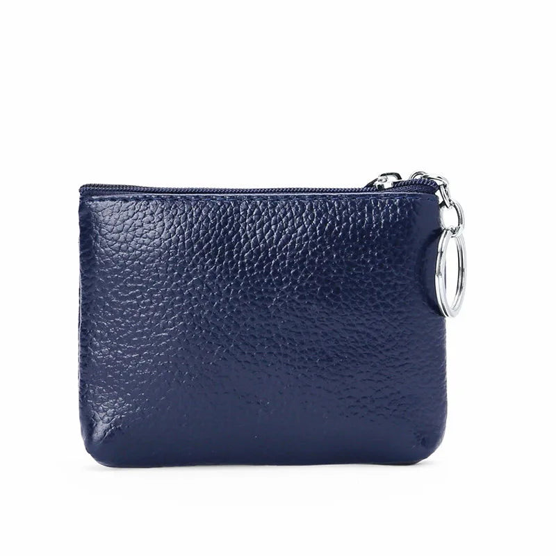 Portamonete in pelle blu scuro con chiusura a zip e anello metallico. Accessorio moda elegante, ideale per organizzare monete e piccoli oggetti.