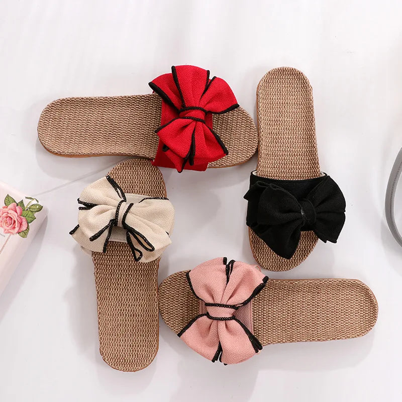 Quattro sandali estivi in paglia con fiocchi colorati: rosso, nero, beige e rosa. Design elegante, perfetti per moda estiva e comfort.