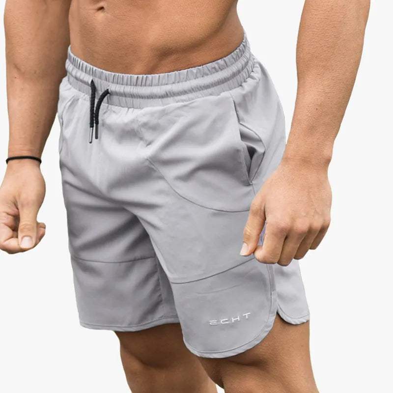 Pantaloncini sportivi grigi da uomo, elastico in vita, tasche laterali, tessuto traspirante, ideali per palestra e fitness.