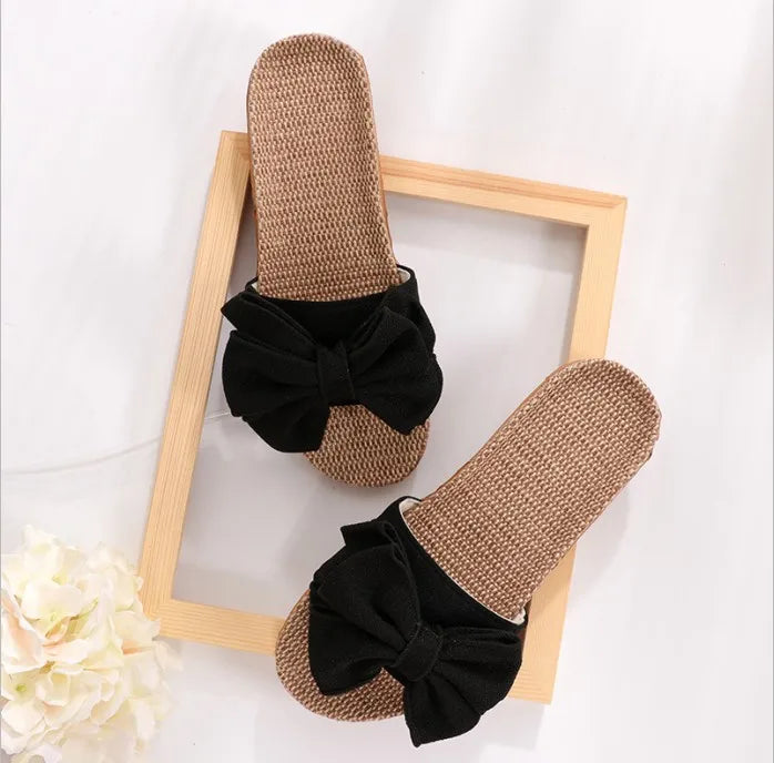 Sandali estivi da donna in paglia con fiocco nero, design elegante e casual, perfetti per la spiaggia o l'uso quotidiano.