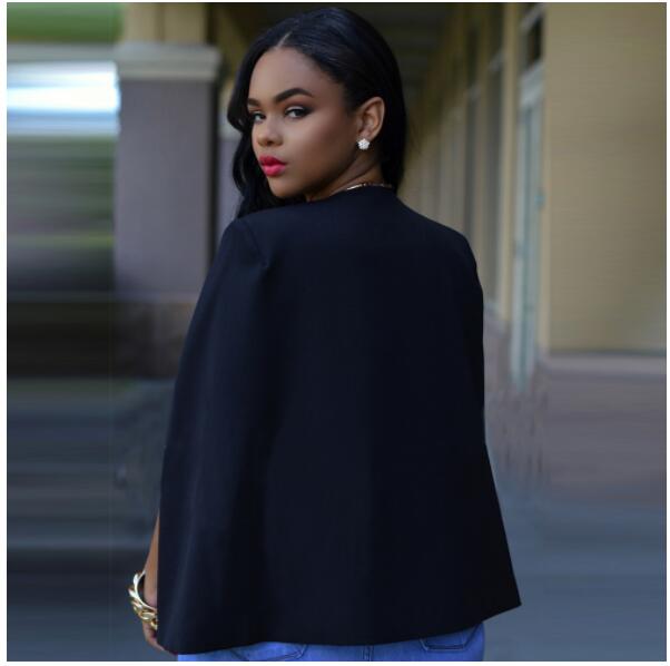 Donna elegante con giacca nera, capelli lunghi e orecchini dorati, guarda indietro. Moda femminile, stile sofisticato, abbigliamento chic.