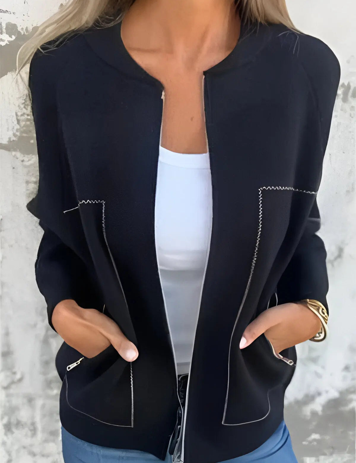 Giacca nera da donna con cuciture bianche, indossata sopra una maglietta bianca. Design elegante, casual, perfetto per moda autunnale.