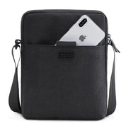 Borsa a tracolla nera con tasca frontale contenente uno smartphone. Design elegante, ideale per uomo e donna. Accessorio moda pratico e versatile.