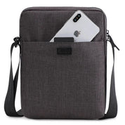 Borsa a tracolla in tessuto grigio scuro con tasca frontale, contenente uno smartphone. Design elegante e pratico per uomo e donna.