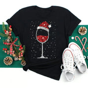Maglietta nera natalizia con calice di vino decorato, pigne, bastoncini di zucchero e scarpe bianche. Design festivo, moda donna Natale.