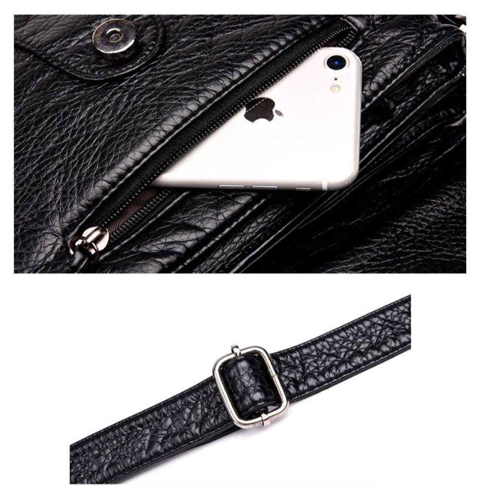 Borsa in pelle nera con cerniera, telefono inserito nella tasca. Cinturino regolabile con fibbia in metallo. Accessorio moda elegante e funzionale.
