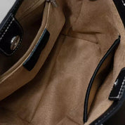 Interno borsa in pelle nera, foderata in tessuto beige, con tasca con zip e chiusura magnetica. Accessorio moda donna elegante e spazioso.