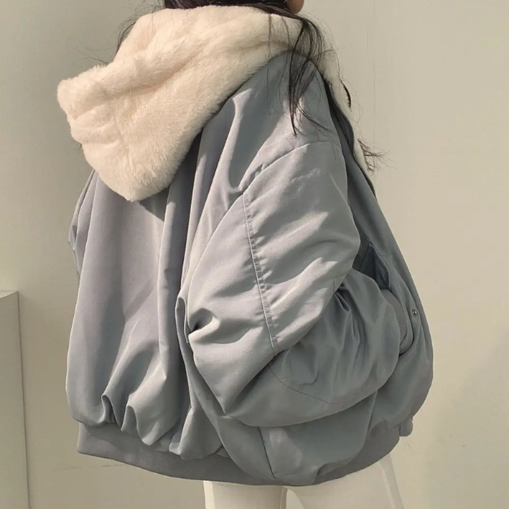 Giacca oversize grigia con cappuccio in pelliccia sintetica, moda invernale donna, stile casual, tessuto caldo e confortevole, tendenza abbigliamento.