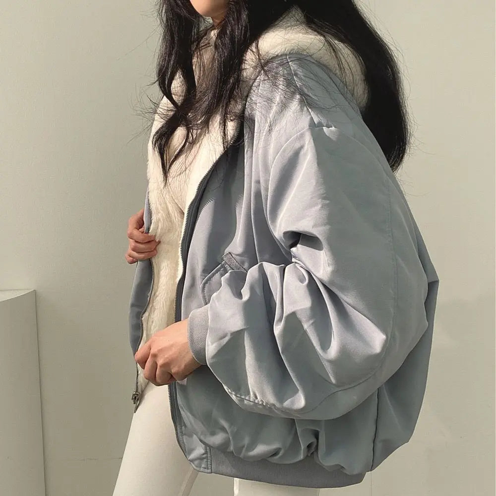 Giacca invernale donna grigia, imbottita, con cappuccio in pelliccia sintetica, stile casual, moda autunno inverno, abbigliamento caldo e confortevole.